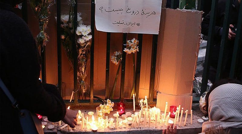 File photo of gathering and protest rally over Iran's downing of Ukraine International Airlines Flight 752. Above flowers and lit candles a notice reads "What is the cost of lying?" Photo Credit: Mohsen Abolghasem, Wikipedia Commons