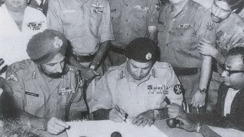 Lt Gen Niazi signing the Pakistan Instrument of Surrender under the gaze of Lt Gen Aurora on December 16, 1971. Photo Credit: Indian Navy, Wikipedia Commons