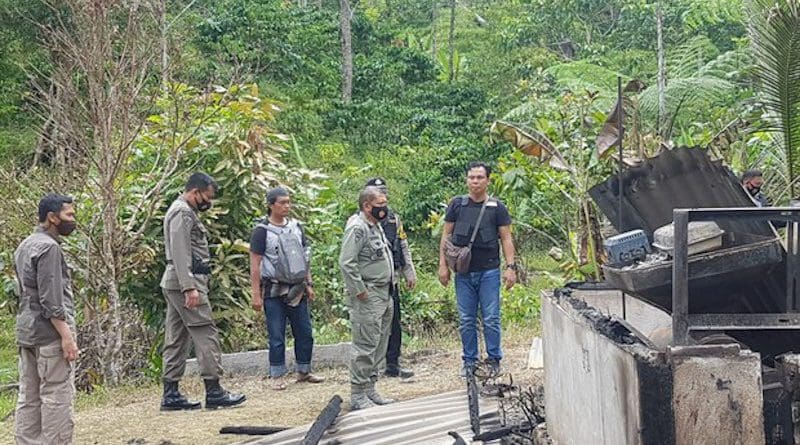 Central Sulawesi Police Chief Abdul Rakhman Baso (second right, front) stands in front of a home burned during an attack in Lembantongoa village blamed on the MIT terrorist group in which assailants killed four local residents, Nov. 28, 2020. Photo: Courtesy of Central Sulawesi police