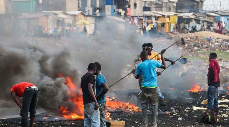 Youths engaging in open burning of waste at a dump. A report says this potentially releases long-term environmental pollutants and toxic substances linked to immunological and developmental impairments. Copyright: Fairphone, (CC BY-NC 2.0). This image has been cropped.