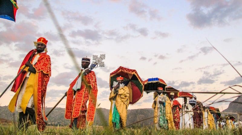 Village elders lead the Timket procession across the village. They walk through their green fields that are flourishing because of their agricultural rehabilitation efforts. Tigray, Ethiopia, 2014. Photo Credit: Nava Derakhshani