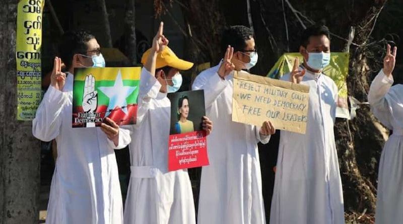Catholic priests hold a picture of State Counselor Aung San Suu Kyi while others display the three-finger salute during an anti-coup protest in Pathein, Irrawaddy division, on Feb. 10. (Photo: OSC Pathein)