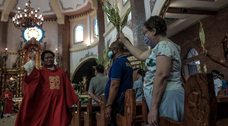 A priest blesses palm fronds as devotees attend Palm Sunday Mass at Santuario De San Juan Evangelista in Dagupan city, Philippines, April 1, 2020. Jojo Riñoza/BenarNews