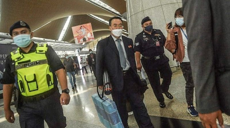 North Korean diplomat Kim Yu Song is escorted by Malaysian police at Kuala Lumpur International Airport, March 21, 2021. [S Mahfuz/BenarNews]
