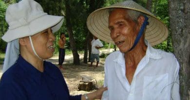 Sister Mary Nguyen Thi Loi talks with Dang Van Loc outside his house in Binh Dinh province on March 2. (Photo: UCA News)