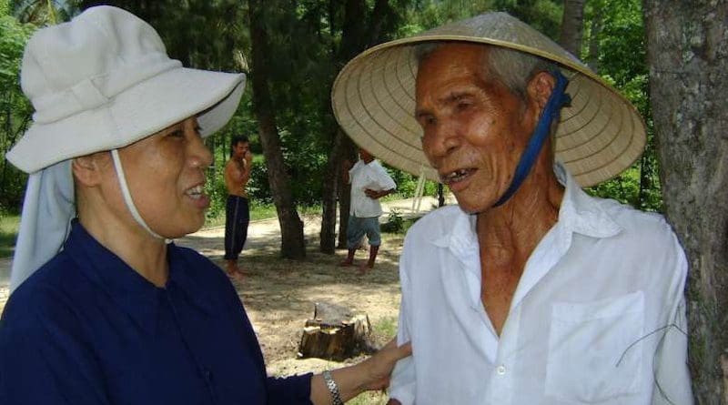Sister Mary Nguyen Thi Loi talks with Dang Van Loc outside his house in Binh Dinh province on March 2. (Photo: UCA News)
