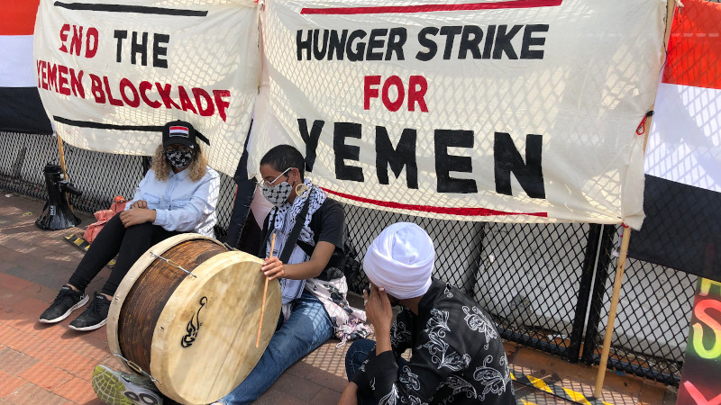 Iman Saleh (with drum) on hunger strike in Washington D.C. to protest the blockade and war against Yemen; seated next to her is Rep. Ilhan Omar. Photo Credit: Code Pink