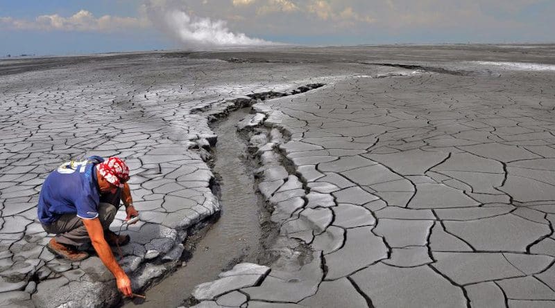 The Lusi eruption: A non accessible 650 m in diameter hot mud pond surrounds the central vents zone (rising plume is seen in the horizon). The erupted mud reaches temperatures of 100 °C and extensive oil slicks can be observed. Photo: Adriano Mazzini/CEED/UiO