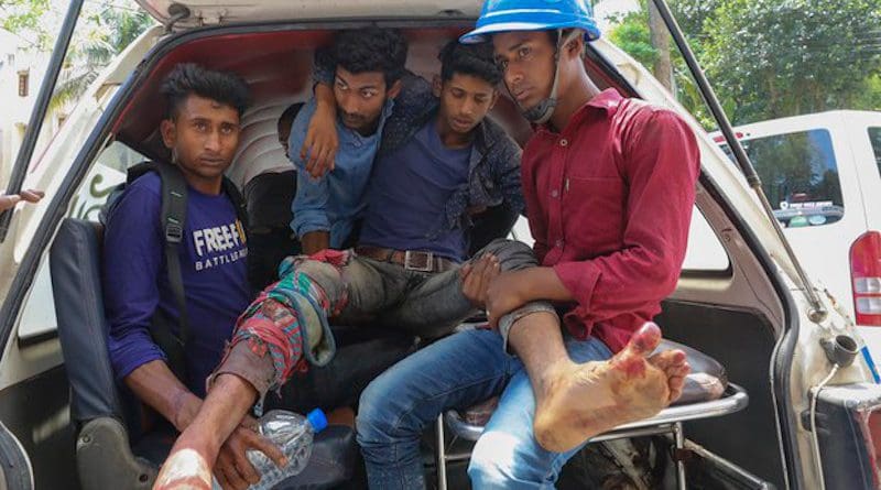 An injured man is loaded into a van after police fired on people protesting over wages and benefits at a Chinese-financed power plant in Banshkhali sub-district, southeastern Bangladesh, April 17, 2021. Photo Credit: BenarNews