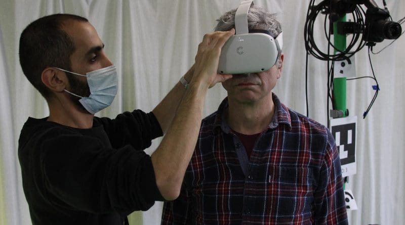 Dr Soltani fits a VR headset to a volunteer CREDIT University of Bath