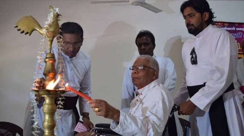 Bishop Rayappu Joseph lights an oil lamp during the launch in 2016 of ‘A Living Hero’, a book about his life. (Photo: UCA News reporter)