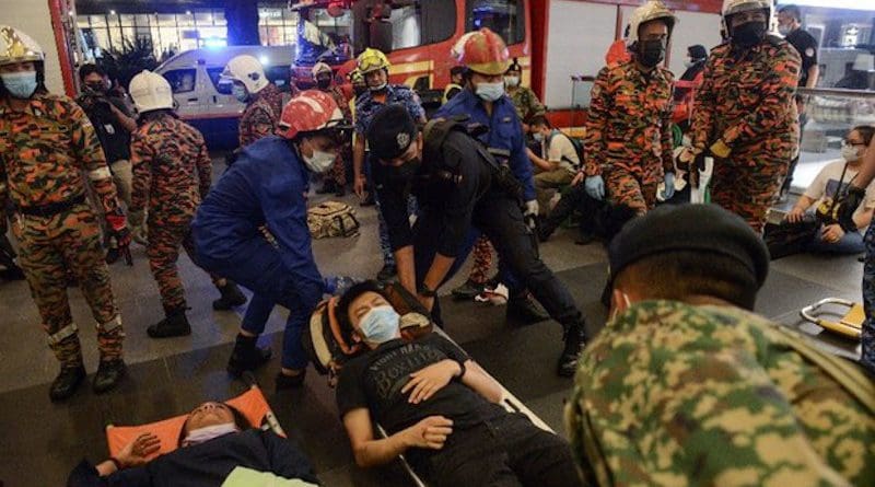 Malaysian search-and-rescue personnel move an injured passenger from a train crash into an ambulance in Kuala Lumpur, May 24, 2021. S. Mahfuz/BenarNews