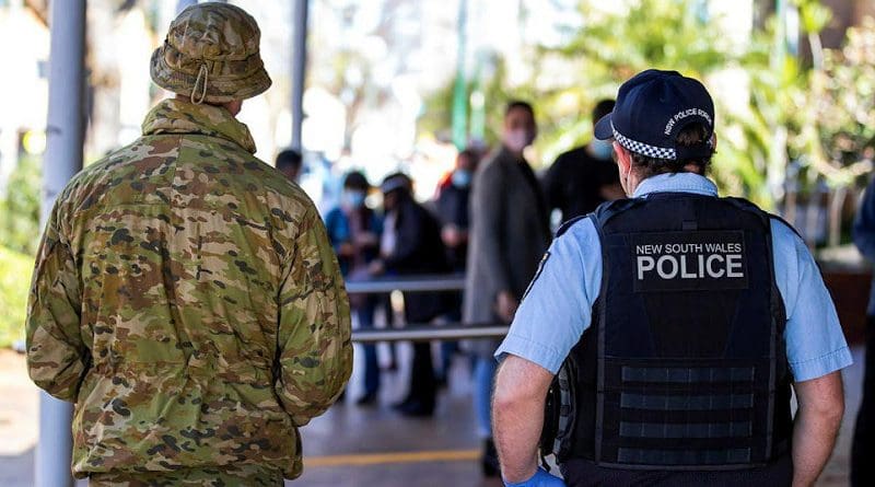 An Australian Army soldier and NSW Police Constable observe Covid-19 Vaccine operations at the Marana Auditorium in Hurtsville as part of the NSW Operation COVID-19 Assist. Photo credit: Corporal Dustin Anderson