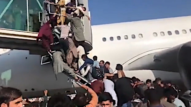 Scene at Kabul airport as civilians seek to board plane to evacuate Afghanistan. Photo Credit: Screenshot of Mehr News Agency video