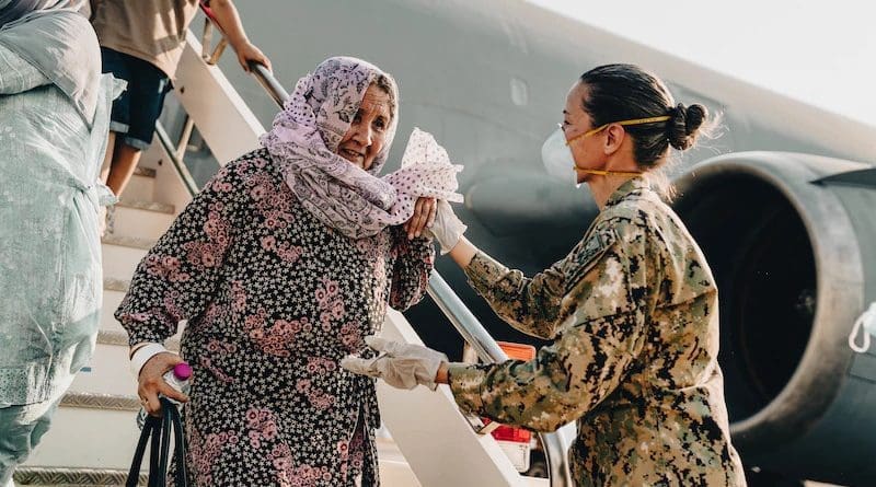 Naval Air Station Sigonella Command Master Chief Anna Wood assists an Afghanistan evacuee deplaning a U.S. Air Force KC-10 Extender at Naval Air Station Sigonella, Aug. 22, 2021. Photo Credit: Marine Corps Sgt. William Chockey