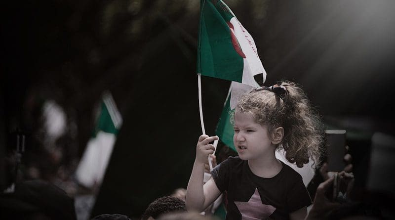 Girl waves an Algerian flag
