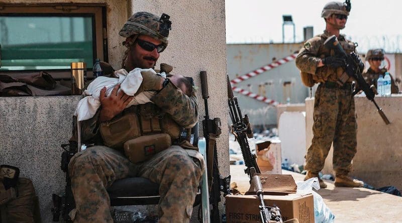 A Marine calms an infant at Hamid Karzai International Airport, Kabul, Afghanistan, Aug. 20. Service members and coalition partners are assisting the Department of State with a non-combatant evacuation operation in Afghanistan. Photo Credit: Marine Corps Sgt. Isaiah Campbell