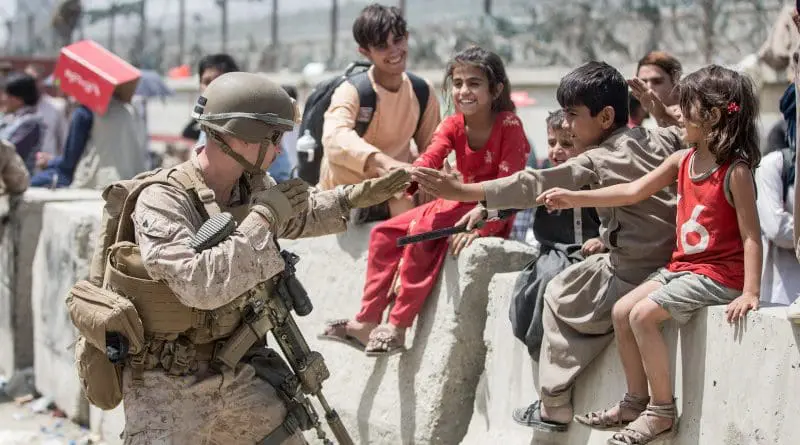 A USMC Marine with Special Purpose Marine Air-Ground Task Force-Crisis Response-Central Command plays with children at Hamid Karzai International Airport in Kabul, Afghanistan. Photo Credit: DOD/Twitter