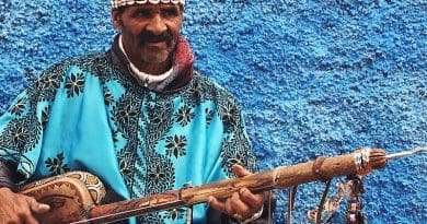 A gnawa performer dressed in traditional gnawa clothing in the Qasbat al-Widaya neighborhood of Rabat, Morocco. Photo Credit: Sambasoccer27, Wikipedia Commons