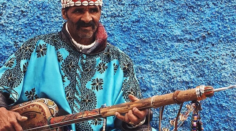 A gnawa performer dressed in traditional gnawa clothing in the Qasbat al-Widaya neighborhood of Rabat, Morocco. Photo Credit: Sambasoccer27, Wikipedia Commons