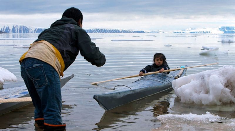 In the photo, Qillaq Danieldsen is teaching a child to paddle near Siorapaluk in northwest Greenland. CREDIT: Carsten Evevang.