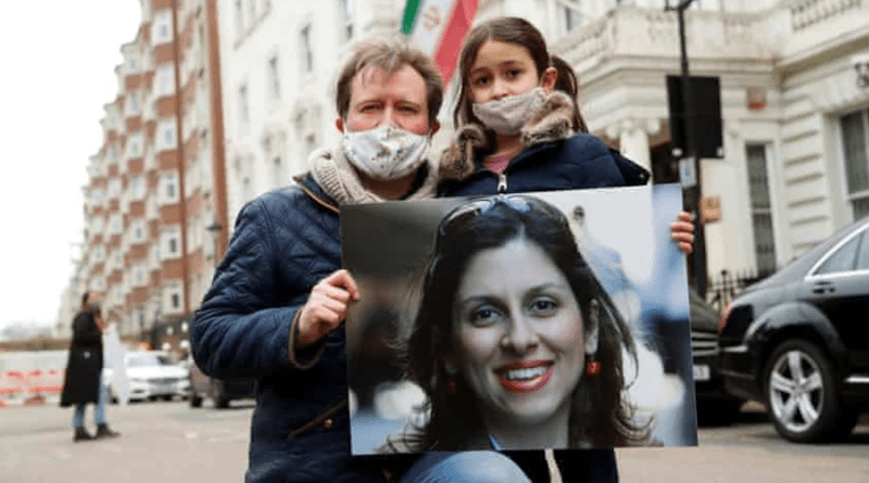 Richard Ratcliffe holds a a picture of his wife, Nazanin Zaghari Ratcliffe, as he and their daughter attend a protest outside the Iranian Embassy in London. (File photo, Social Media)