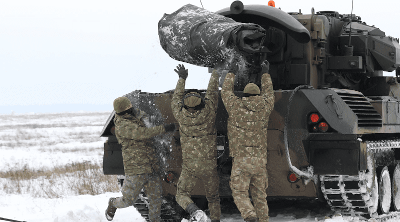 Members of the Romanian Army Air Defense Detachment, 8th rotation, heave a tarp into their vehicle after a joint combat live fire of the Gepard Air Defense System, Bemowo Piskie Training Area, Poland, Feb. 2, 2021. Photo Credit: Army Staff Sgt. Elizabeth Bryson