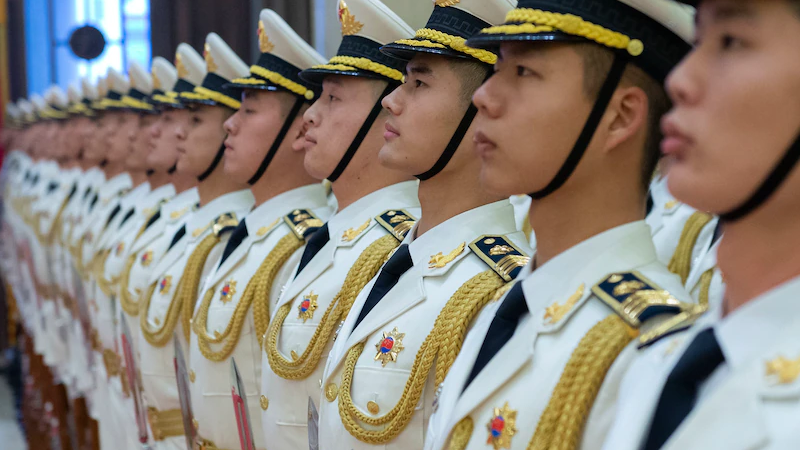 Chinese service members stand in formation at the Beijing headquarters of the Chinese army. Photo Credit: Navy Chief Petty Officer Elliott Fabrizio