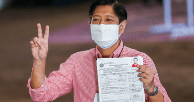 Candidate Ferdinand Marcos Jr., the son and namesake of the late Philippine dictator, flashes a victory sign as he shows his certificate of candidacy after filing to join the May 2022 presidential race, in Manila, Oct. 6, 2021. [Rouelle Umali/BenarNews]