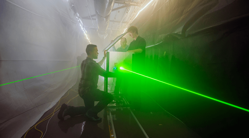 Andres Sanchez, left, Jeremy Wright, center, and Brian Bentz prepare for an optical test in Sandia National Laboratories’ fog facility. Bentz is leading a three-year project to use computational imaging to detect, locate and image objects in fog. This photo was taken prior to the COVID-19 pandemic. CREDIT: Photo by Randy Montoya