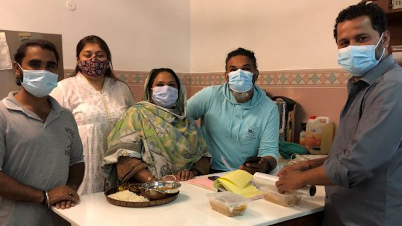 Alia Chughtai (standing at the back), a journalist with filmmaker Akhlaque Mahesar (right, behind the table), and others in their team at Aur Chaawal (And Rice). Chughtai believes in using local fresh ingredients that are healthy and planet-friendly. Her method of cooking fits in with the Barilla Center for Food and Nutrition’s Double Pyramid. Credit: Zofeen T. Ebrahim/IPS