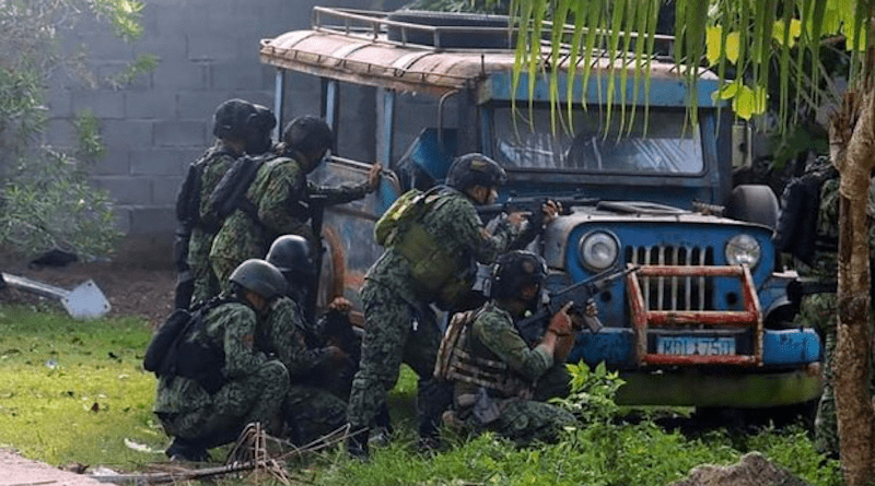 Police take position behind a parked vehicle during a raid that left six dead in Pikit, Cotabato province, southern Philippines, Dec. 29, 2021. Photo Credit: Philippine National Police handout