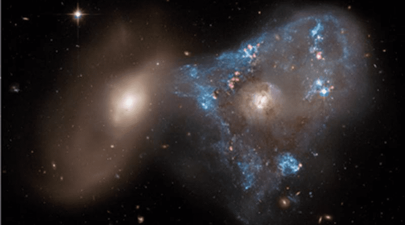 A spectacular head-on collision between two galaxies fueled the unusual triangular-shaped star-birthing frenzy, as captured in a new image from NASA’s Hubble Space Telescope. The interacting galaxy duo is collectively called Arp 143. The pair contains the glittery, distorted, star-forming spiral galaxy NGC 2445 at right, along with its less flashy companion, NGC 2444 at left. CREDIT Image Credits: NASA, ESA, STScI, Julianne Dalcanton (Center for Computational Astrophysics / Flatiron Inst. and University of Washington); Image Processing: Joseph DePasquale (STScI)