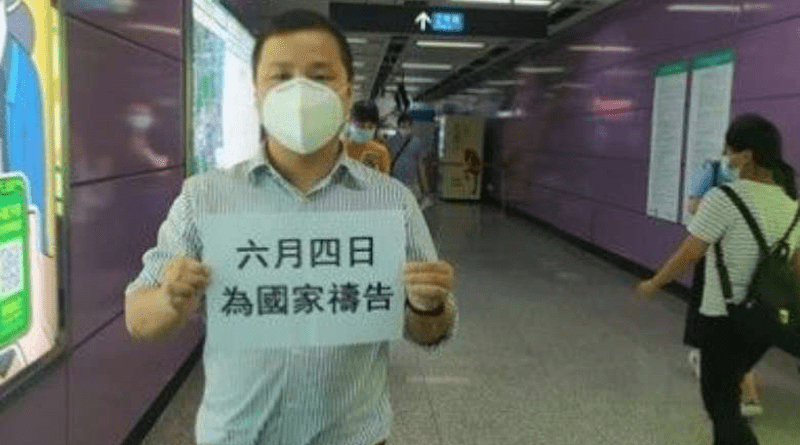 Geo Heng holds a sign at a subway station in Guangzhou city that reads 'June 4, pray for the nation.' (Photo: Facebook/Henry Gao)