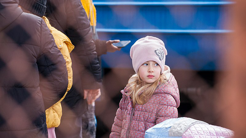 A young refugee from Ukraine in Przemyśl train station in Poland. Photo Credit: Mirek Pruchnicki, Wikipedia Commons