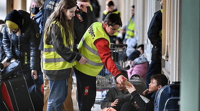 Volunteers assist refugees from Ukraine in a Polish train station. Photo Credit: Pakkin Leung@Rice Post, Wikipedia Commons