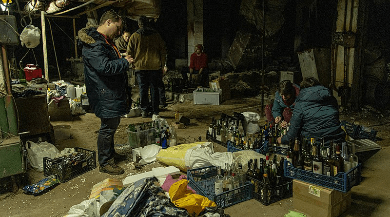 Civilians in Kyiv prepare Molotov cocktails. Photo Credit: Yan Boechat/VOA