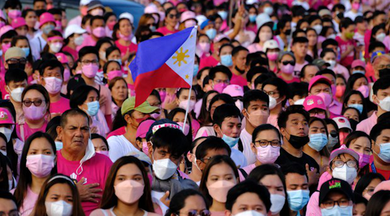 The Philippine flag flutters in the wind as supporters sing the national anthem during the presidential campaign stop of Vice President Leni Robredo in San Fernando city, north of Manila, April 9, 2022. Photo Credit: Jason Gutierrez/BenarNews