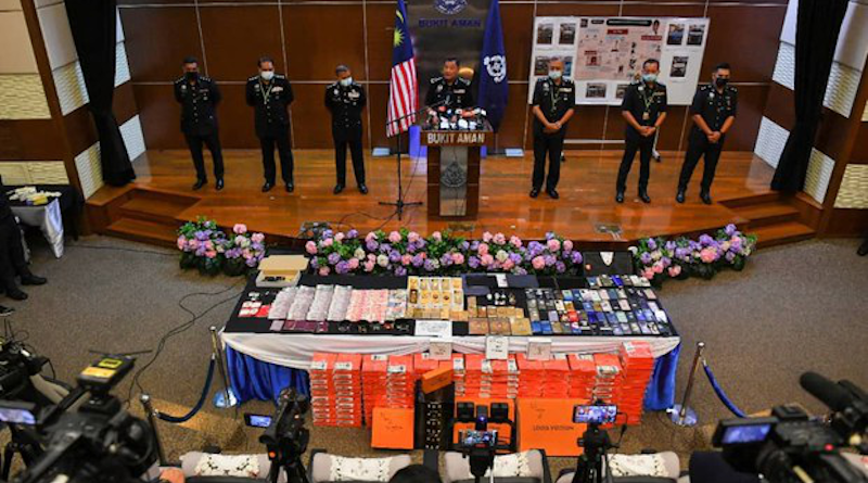 Malaysian Police Inspector-General Abdul Hamid Bador (center) displays cash and items seized during a series of raids against the Nicky Gang, during a news conference at Federal Police Headquarters in Kuala Lumpur, March 30, 2021. [S. Mahfuz/BenarNews]