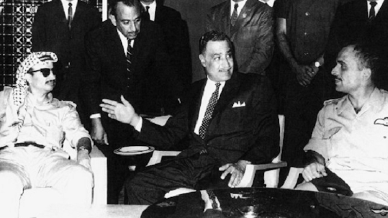 Egyptian President Gamal Abdel Nasser brokering an agreement to end the Black September conflict between Yasser Arafat (left) of the PLO and King Hussein (right) of Jordan. The negotiations are taking place at the Cairo Hilton. Photo Credit: Author unknown, Wikipedia Commons