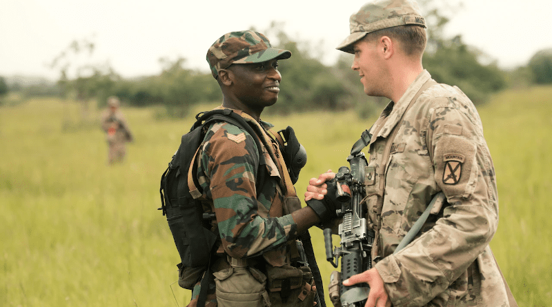 A Ghanaian soldier greets a U.S. soldier from the 1st Battalion, 32nd Infantry Regiment, during a field training exercise for the United Accord exercise at the Bundase Training Camp in Ghana, July 16, 2018. United Accord 2018 is hosted by the Ghanaian armed forces and U.S. Army Africa and consists of four combined, joint components: a command post exercise, field training exercise, jungle warfare school and medical readiness training exercise. Navy Photo by Petty Officer 2nd Class Douglas Parker
