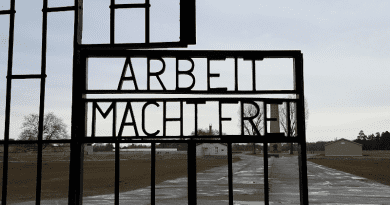 Photo caption: the gate at Sachsenhausen concentration camp, with the barren “parade ground” visible. Credit: Creative Commons image
