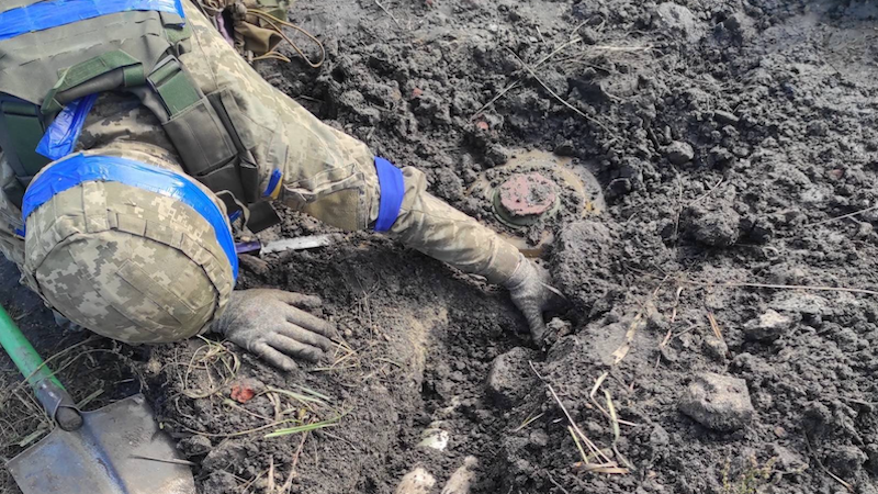 Ukrainian soldier removes Russian landmine. Photo Credit: Ukraine Defense Ministry