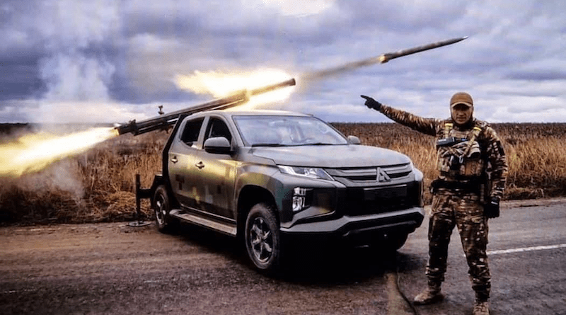 A Ukrainian soldier points at a rocket being launched from a pickup. Photo Credit: Ukraine Defense Ministry