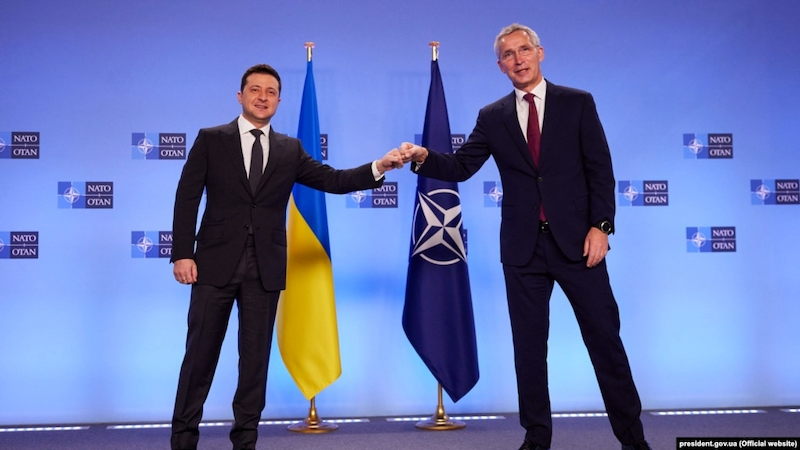 Ukrainian President Volodymyr Zelensky (left) and NATO Secretary-General Jens Stoltenberg bump fists at a press conference in Brussels in December 2021. Photo Credit: Ukraine Government, RFE/RL