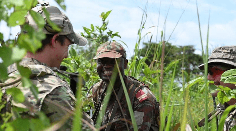 U.S. Army Green Berets assigned to 3rd Special Forces Group (Airborne) and Alpha platoon leader from the 1st Commando Parachute Battalion rally to discuss mission progress during a Joint Combined Exercise Training (JCET) in Ouassa, Benin, Sept. 7, 2022. (U.S. Air Force photo by Staff Sgt. Jasmonet Holmes)