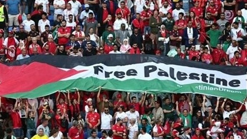 Tunisian fans fly the Palestinian flag during the game against Australia, Al-Janoub Stadium, Qatar. Photo Credit: Tasnim News Agency