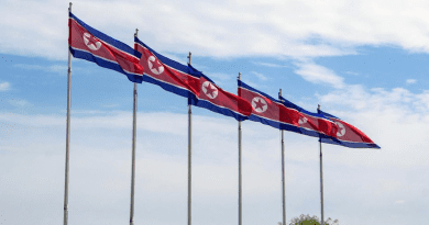 Flags of the Democratic People's Republic of Korea fly in Pyongyang. Photo Credit: Unsplash/Micha Brändli