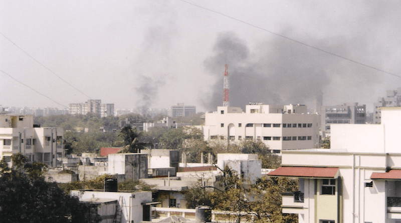 The skyline of Ahmedabad, Gujarat, India filled with smoke as buildings and shops are set on fire by rioting mobs. Photo Credit: Aksi great, Wikipedia Commons