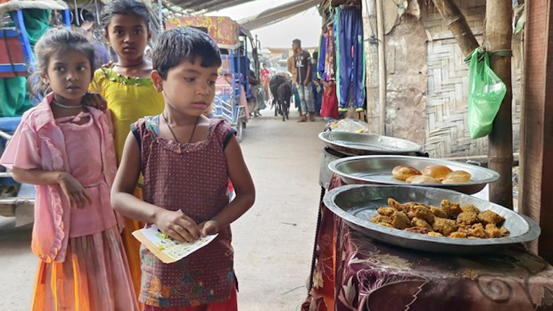 Rohingya children look at food offered at a shop in the Leda refugee camp in Teknaf, Cox’s Bazar, Bangladesh. Photo Credit: Abdur Rahman/BenarNews